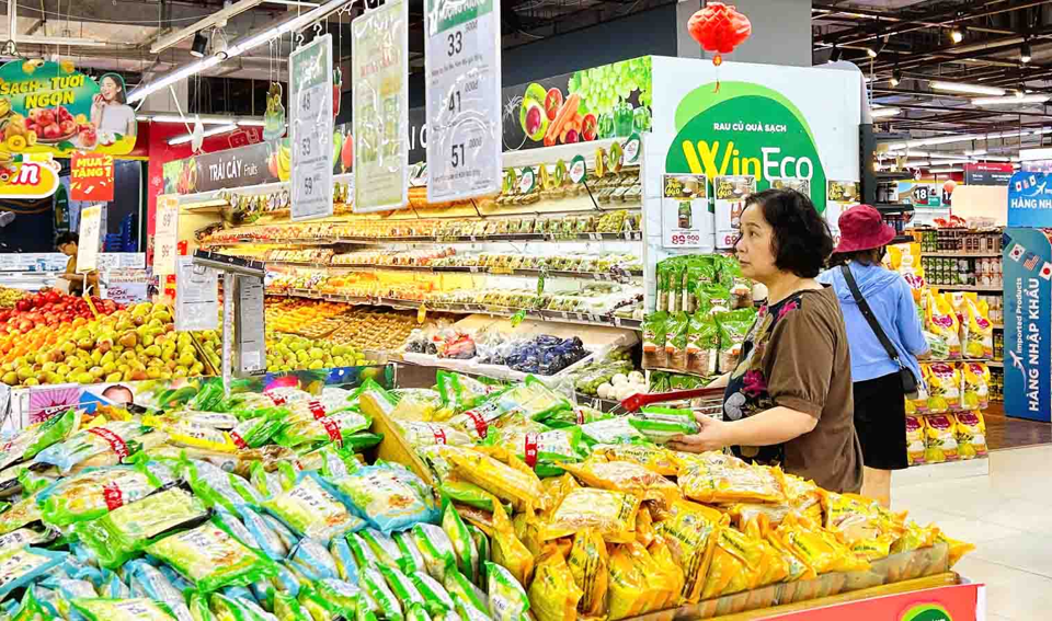 Người ti&ecirc;u d&ugrave;ng mua sản phẩm giảm gi&aacute; tại si&ecirc;u thị WinMart. Ảnh: Ho&agrave;i Nam