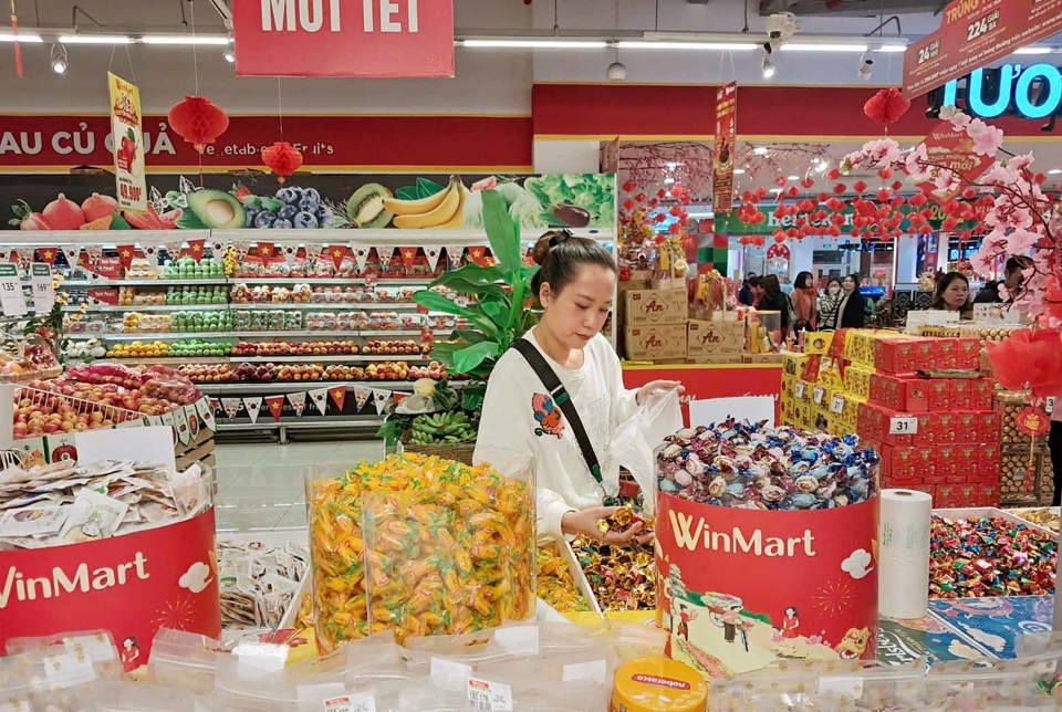 Người ti&ecirc;u d&ugrave;ng mua b&aacute;nh kẹo thời điểm cuối năm tại si&ecirc;u thị Winmart. Ảnh: Ho&agrave;i Nam