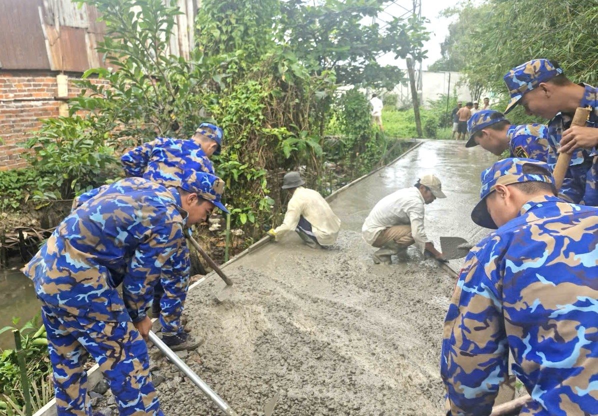 hinh-2 hinh-2.-can-bo-dvtn-hai-don-vi-chung-tay-cung-ba-con-be-tong-hoa-tuyen-duong-giao-thong-nong-thon.jpg