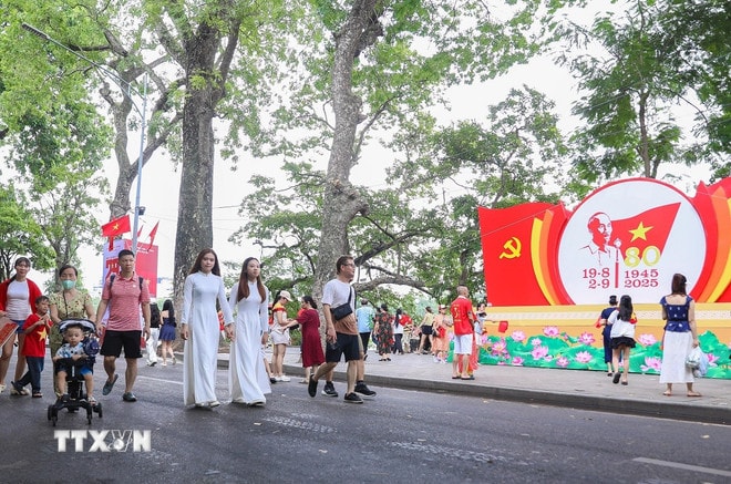 Du khách vui chơi tại khu vực phố đi bộ hồ Hoàn Kiếm. (Ảnh: Thành Phương/TTXVN) ttxvn-di-bo.jpg